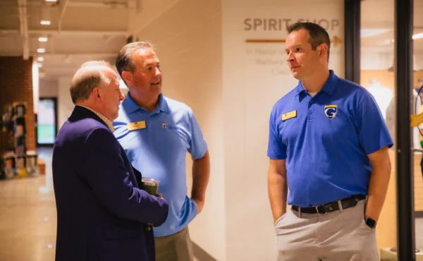 Three men in conversation near a 